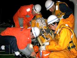 夜間、航空機で発見したダミー人形を巡視船に収容する乗組員